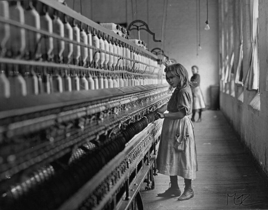 En flicka står vid en vvmaskin runt förra sekelskiftet